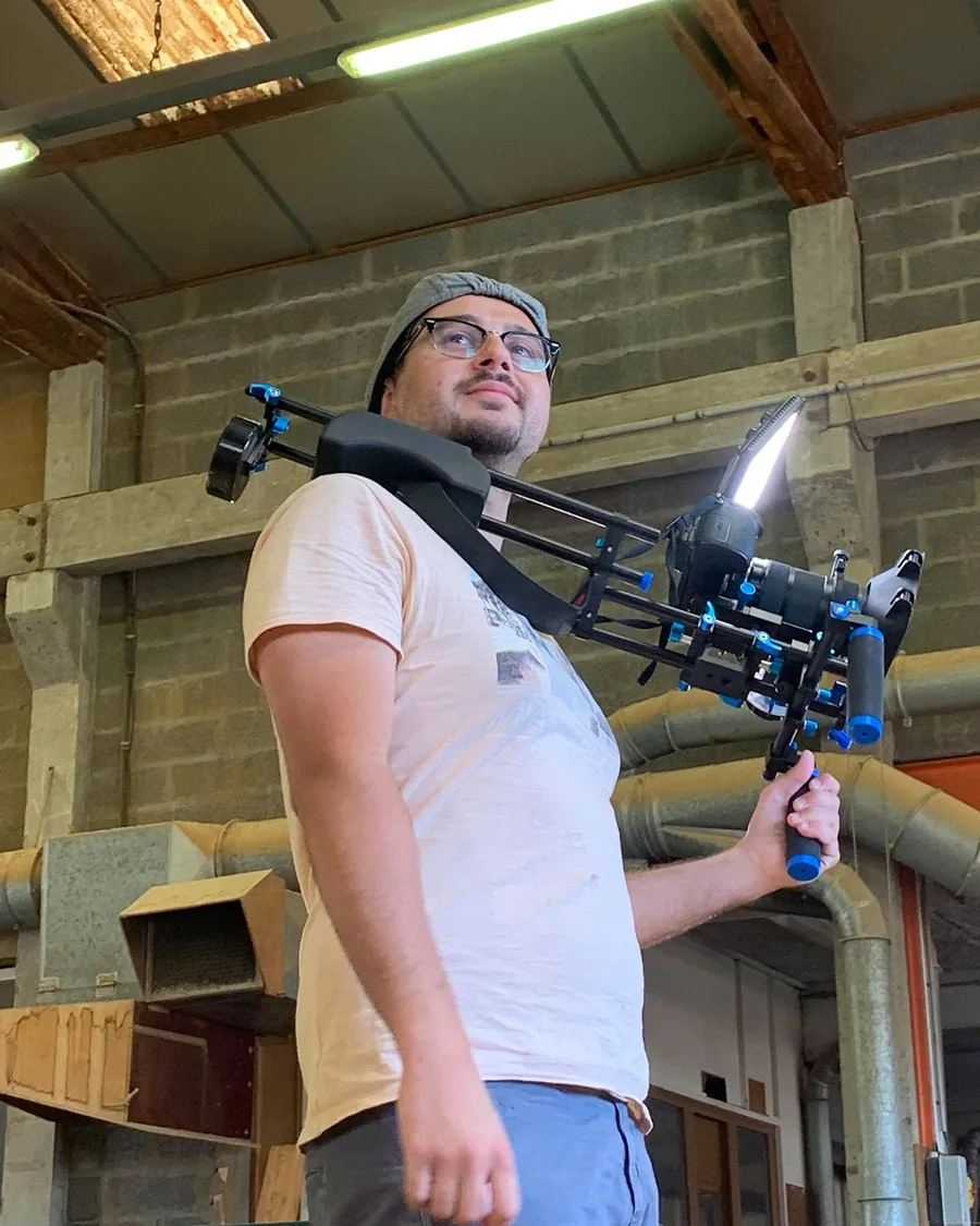 Corentin Maïly filmant caméra à l’épaule dans une usine de Saône-et-Loire
